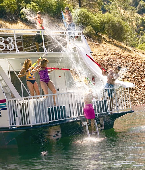 Family on a houseboat playing with water guns
