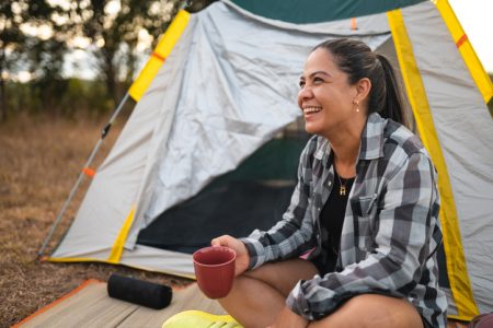 woman drinking coffee outside tent